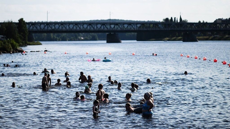 People bathing at the Ounaskoski Beach at the Arctic Circle in Rovaniemi, Finnish Lapland