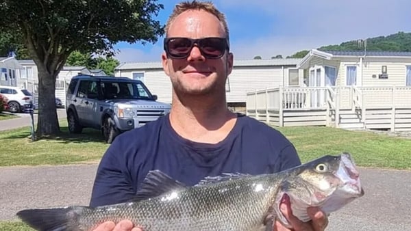 Picture of Lee Claydon holding a fish Mr Claydon died after falling at an Oasis concert in Wembley