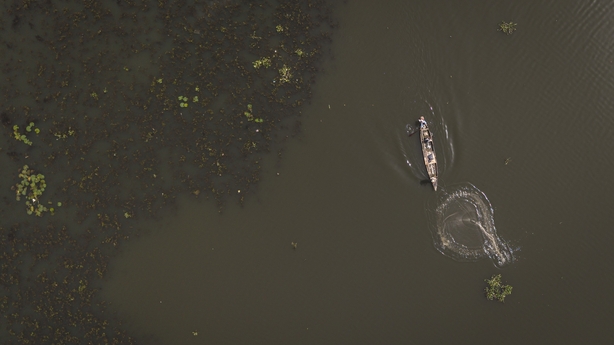Squeezed By Urban Growth, Nigerian Fishermen Stick To Tradition 3 aerial view of a fisherman throwing a net into jabi lake in nigeria