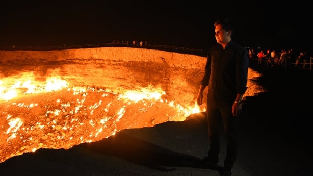 A man stands beside a gas crater in Turkmenistan
