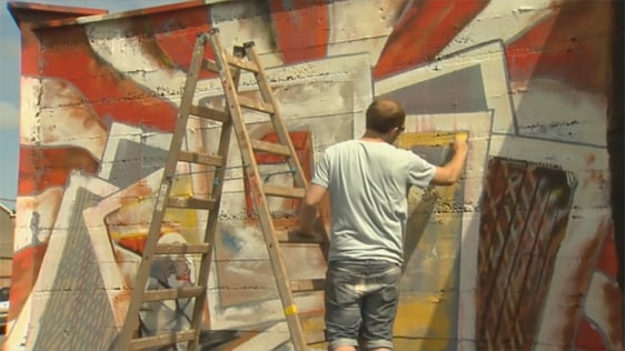 A street artist creating a mural for the Waterford Walls festival in 2015