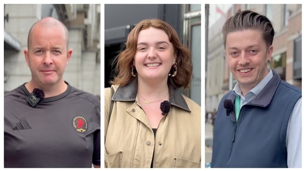 image shows three Oasis fans outside the pop-up shop in Dublin - two men and one woman