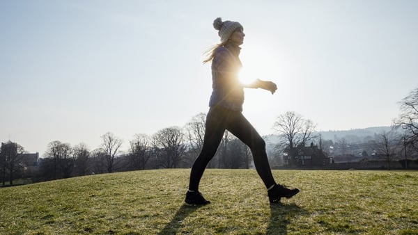 Woman walking in a field in the morning