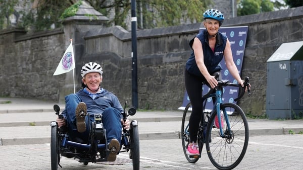 Limerick man Conor O’Dea and his custom-built trike at City Hall, Limerick ahead of the 2025 Tour de Munster alongside Paula O'Keefe from Bluebird Care Limerick
