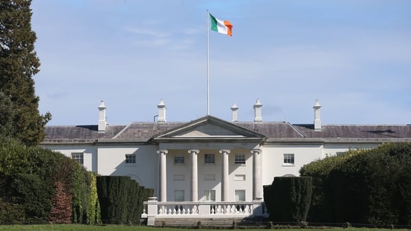 A photo of Aras an Uachtarain, with the Irish flag above and blue skies