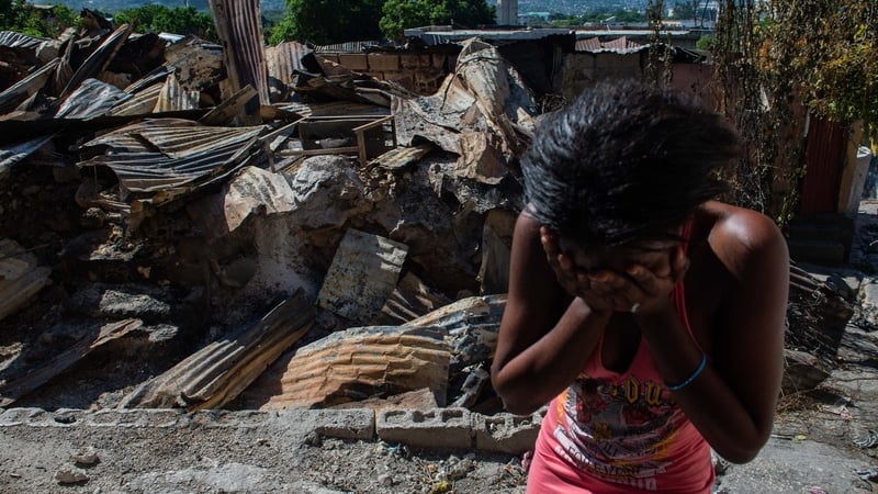 A woman cries outside her house after armed gangs set it on fire in the Post Marchand neighbourhood of Port-au-Prince