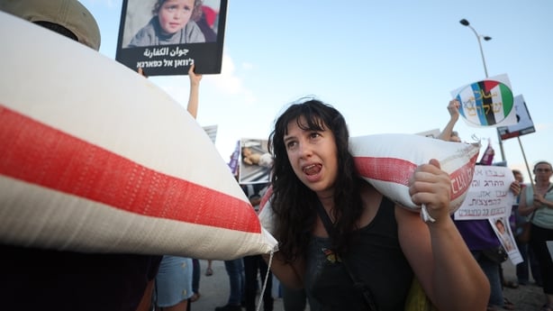 EREZ, ISRAEL - AUGUST 6: Hundreds of people gathered near the Erez crossing between Israel and the Gaza Strip to protest the ongoing war and call for an end to the severe hunger crisis in Gaza on August 6, 2025 in Erez, Israel. Demonstrators carrying sacks of flour and photos of children who died du