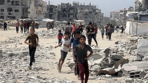 Palestinian children run toward food parcels dropped by a military aircraft in Jabalia, northern Gaza