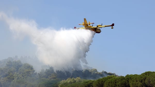 A plane dump water as part of firefighting efforts in sicily