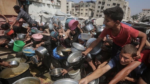 GAZA CITY, GAZA - AUGUST 10: Starving Palestinians including women and children holding pots wait to receive food distributed by a charity organization as Israel continue to block humanitarian aid from reaching the Gaza Strip on August 10, 2025. (Photo by