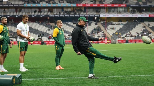 South African head coach Rassie Erasmus (R) kicks the ball
