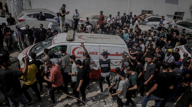 Relatives and colleagues of slain Al Jazeera staff follow an ambulance during the funeral procession in Gaza City