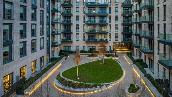 A picture of high rise buildings around a courtyard with a garden in the middle of it
