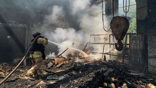 A firefighter extinguish a blaze following a Russian drone strike on a warehouse storing food products in Sloviansk, in the northern part of the Donbas region