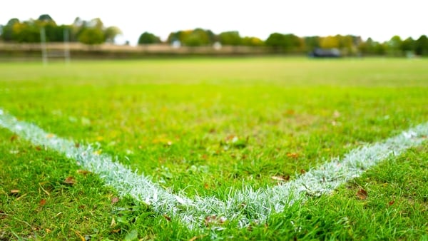 Distant rugby goal seen in shallow focus of the corner of painted white lines on a school's rugby field