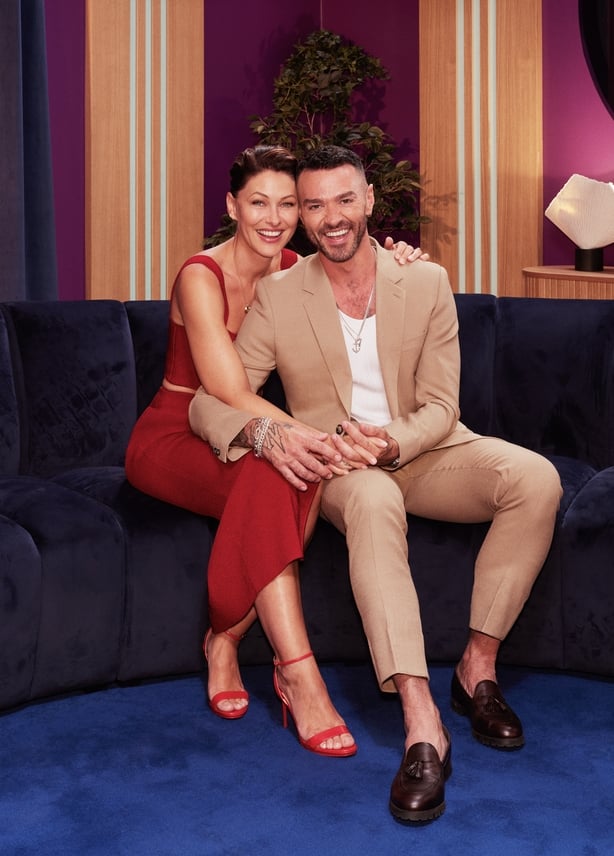 Love is Blind hosts Emma Willis and Matt Willis hold hands as they pose for a photo