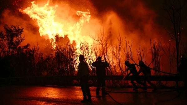 Firefighters are pictured working on extinguishing a wildfire near the city of Patras in western Greece