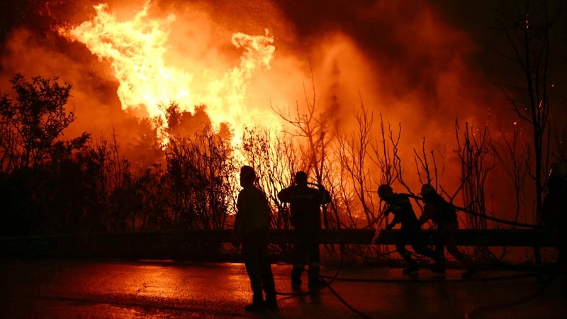 Firefighters are pictured working on extinguishing a wildfire near the city of Patras in western Greece