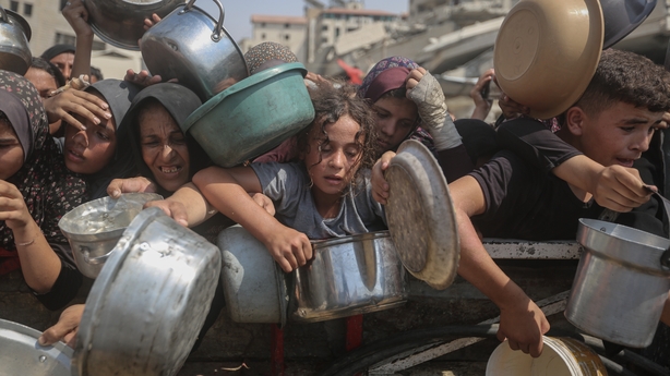Starving Palestinians including women and children holding pots wait to receive food distributed by a charity organisation as Israel continue to block humanitarian aid from reaching Gaza 