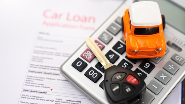 Image of a car loan contract, a calculator, a car key and a toy car
