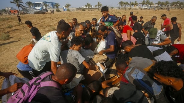 Palestinians receive humanitarian aid packages parachuted from planes into Deir Al Balah