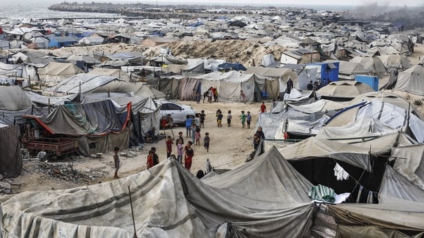 Palestinians stand outside tents in Gaza City, Gaza