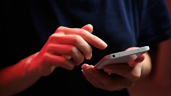 Stock image shows a close up of a person using a mobile phone