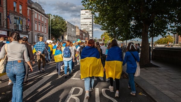 Ukrainians draped in Ukrainian flags walk down the quays in Dublin while celebrating Ukrainian Independence Day
