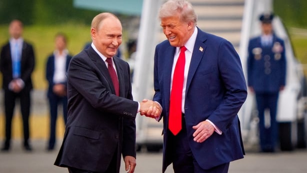 Vladimir Putin shaking Donald Trump's hand 