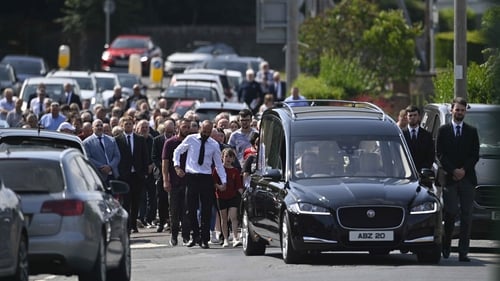 The funeral cortege and hearse arriving at the funeral of Stephen Brannigan at St Brigid's church in Downpatrick, Co Down