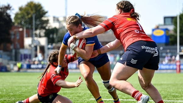 16 August 2025; Kathy Baker of Leinster on her way to scoring her side's second try despite the efforts of Munster players Aoife Fleming, left, and Gráinne Burke during the Vodafone Women’s Interprovincial Championship Round 2 match between Leinster and M