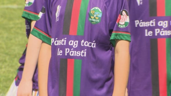 A child wearing a Páistí ag tacú le páistí jersey at a hurling blitz in Belfast.