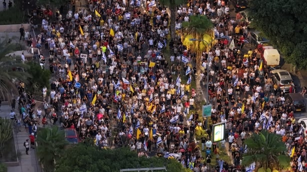 People gather to stage a protest as part of a one-day general strike in Tel Aviv