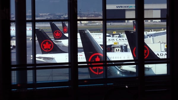 Tails of Air Canada planes with the airline's logo at an airport
