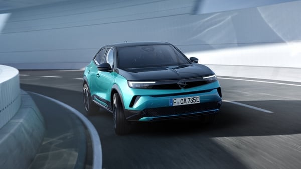 A front view of a teal green coloured car