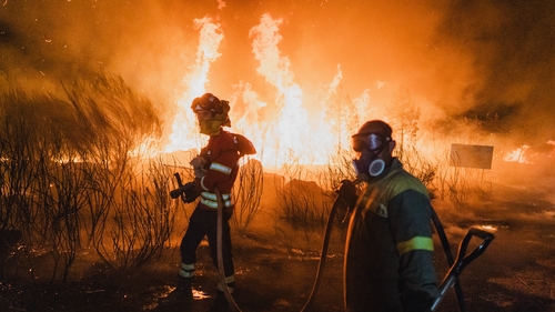 Firefighters work overnight to contain a wildfire threatening residential areas in the parish of Bouses, located in Oimbra, Ourense, Galicia