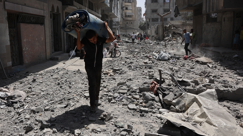Palestinians salvage items from the rubble of homes destroyed in Israeli strikes on the southern al-Zeitoun neighbourhood in Gaza