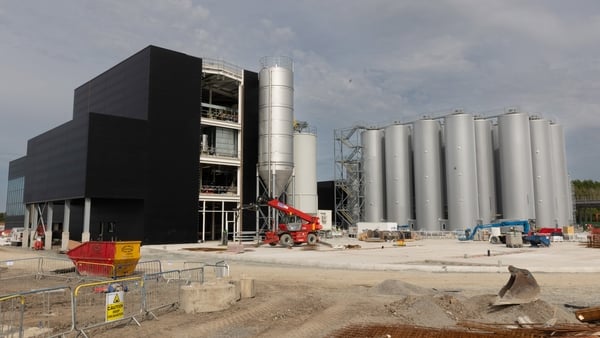 A building site with huge circular containers and an office building