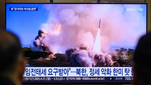 People watch a news broadcast at Seoul Railway Station, showing footage a missile launch in North Korea in April