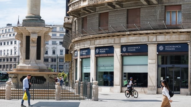 A bank branch beside a statue in an Italian street