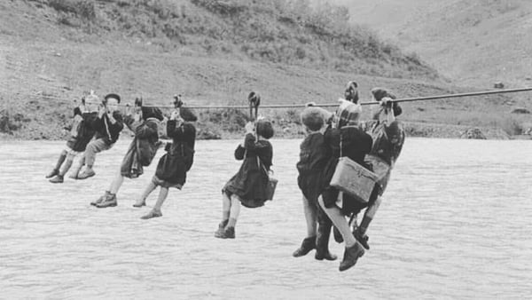 Children crossing the river on their way to school, Italy 1959.
