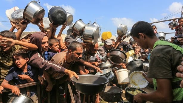  Palestinians, including children, who are struggling to access food due to Israel's blockade and ongoing attacks on the Gaza Strip, wait in line to receive hot meals distributed by the charity organization at Al-Mawasi area in Khan Yunis, Gaza on August 21, 2025. Due to Israel's blockade and ongoin