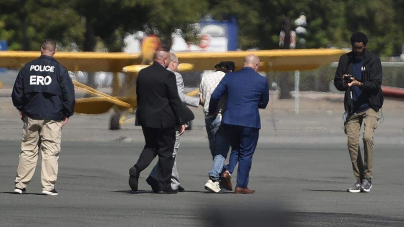 ICE officers and Florida Lt Gov Jay Collins escort Harjinder Singh toward a waiting plane at Stockton Metropolitan Airport for Mr Singh's extradition to Florida