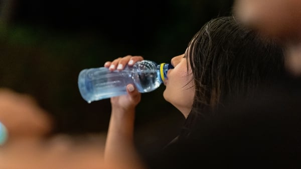 A woman drinks water from a bottle