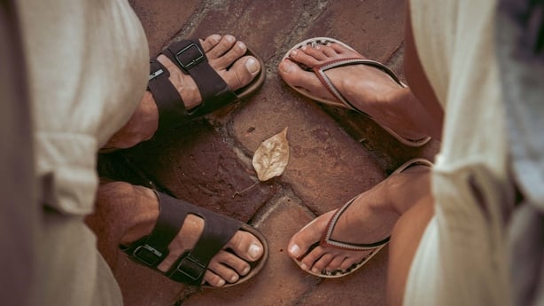 Two pairs of feet in sandals