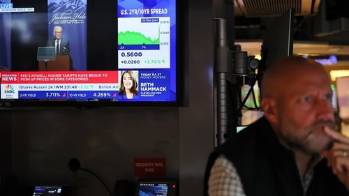 Federal Reserve Chair Jerome Powell's Jackson Hotel speech displayed on a television as traders work on Wall Street
