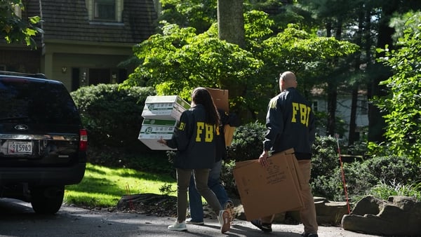 FBI agents work outside the home of John Bolton, former national security adviser to President Trump in Bethesda, Maryland