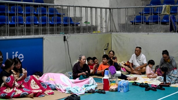 People take shelter inside a gym ahead of a typhoon to hit Vietnam