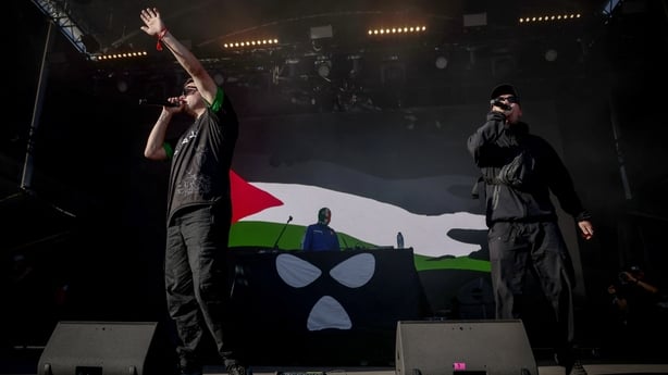 Kneecap perform on stage in front of a Palestinian flag on a screen during a concert at the Rock en Seine music festival in Saint-Cloud, near Paris, on August 24, 2025
