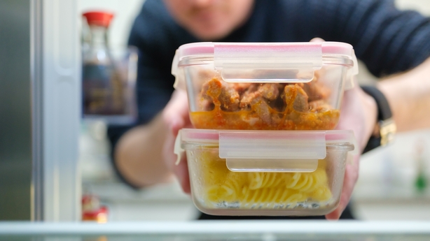 Man taking cooked pasta and chicken leftovers from the refrigerator